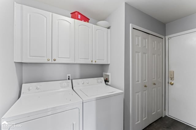 clothes washing area featuring cabinets, dark hardwood / wood-style flooring, and washer and clothes dryer