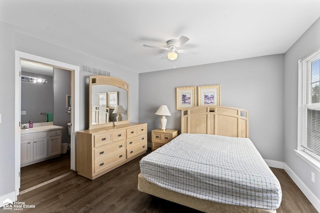 bedroom with dark wood-type flooring, ceiling fan, connected bathroom, and sink