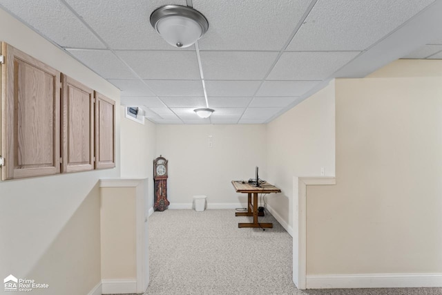 interior space featuring light colored carpet and a paneled ceiling