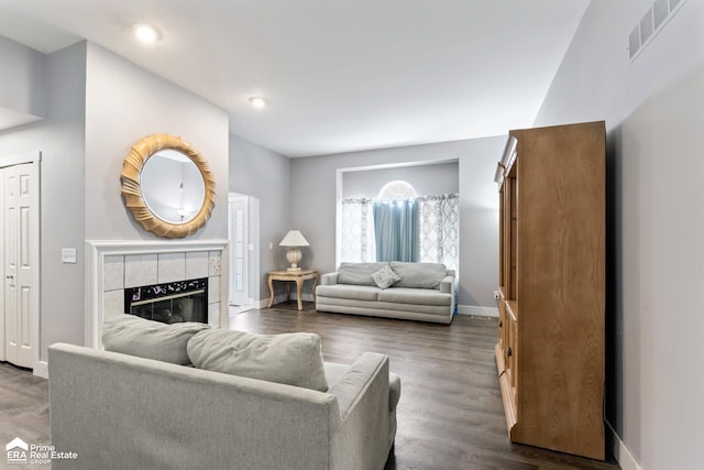 living room featuring dark hardwood / wood-style flooring and a tile fireplace