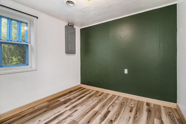 1722 N Benson Rd, Fountain, MI 49410 - empty room featuring electric panel, wood finished floors, baseboards, and ornamental molding