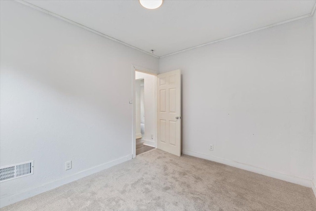 carpeted spare room featuring ornamental molding