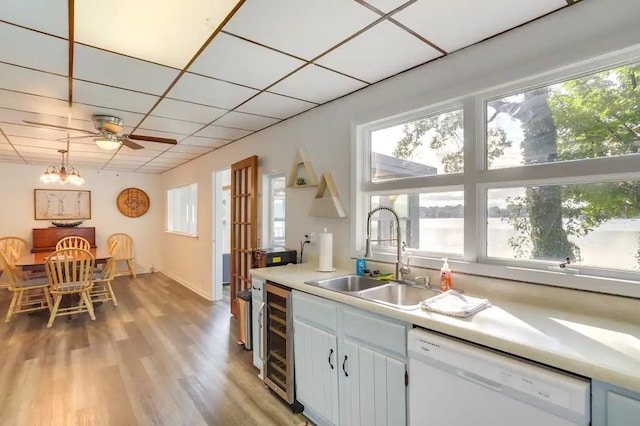 kitchen featuring dishwasher, white cabinets, sink, light hardwood / wood-style floors, and beverage cooler