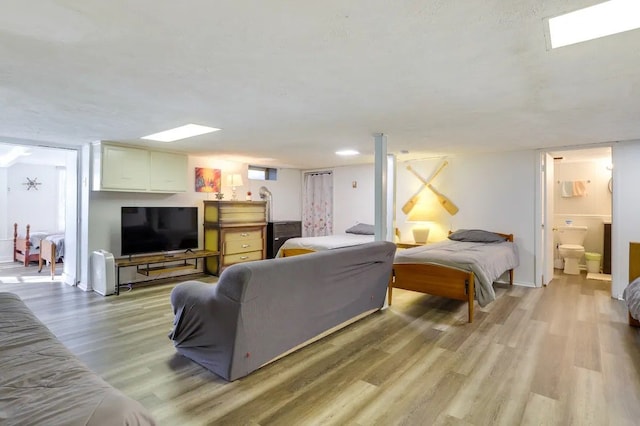 bedroom featuring light hardwood / wood-style floors and connected bathroom