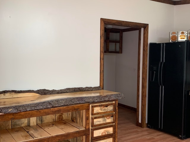 kitchen featuring hardwood / wood-style flooring and black fridge