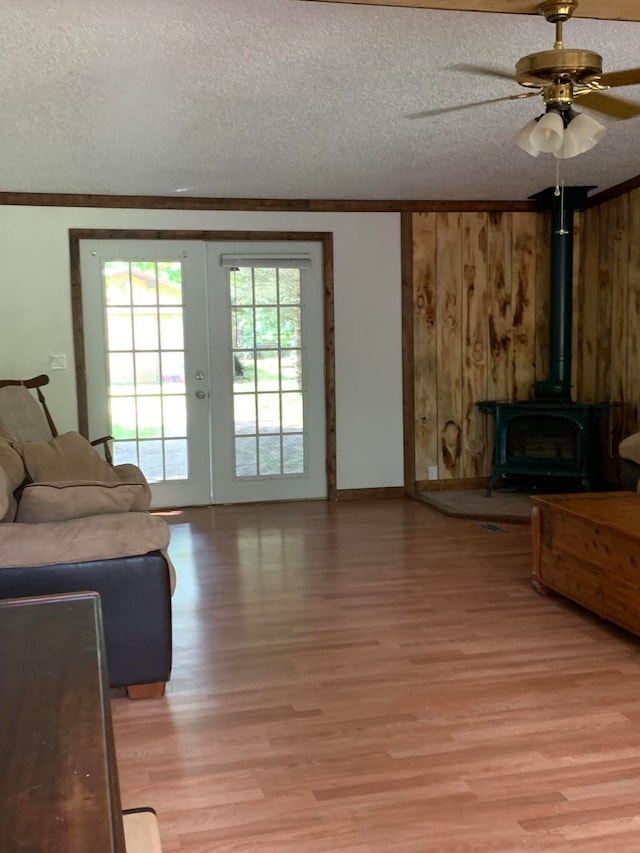 living room with ceiling fan, a textured ceiling, and light wood-type flooring