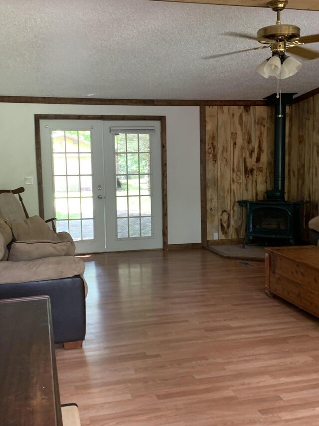 15070 Rapids Dr, Hersey, MI 49639 - living room with light wood-style floors, ornamental molding, a textured ceiling, ceiling fan, and a wood stove