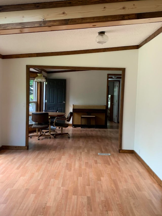 living room with lofted ceiling with beams, light hardwood / wood-style floors, and ornamental molding