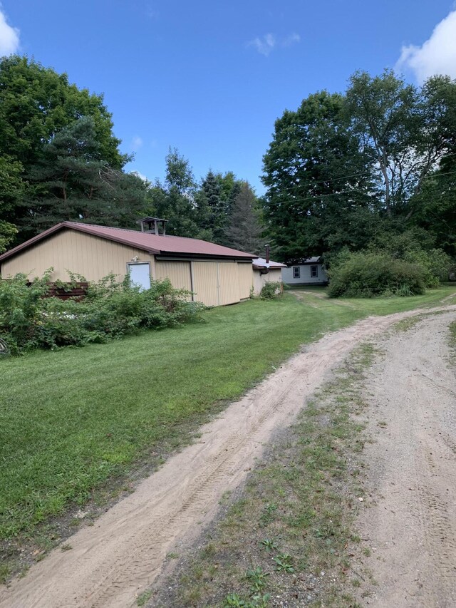 15070 Rapids Dr, Hersey, MI 49639 - view of side of property with driveway, a yard, a pole building, an outbuilding, and a garage