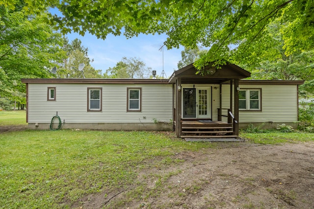 rear view of property featuring a lawn