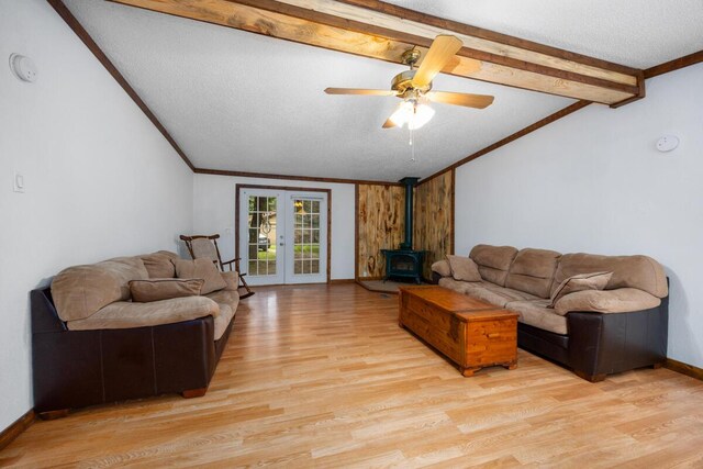 15070 Rapids Dr, Hersey, MI 49639 - living room featuring a wood stove, light wood-style flooring, crown molding, ceiling fan, and baseboards