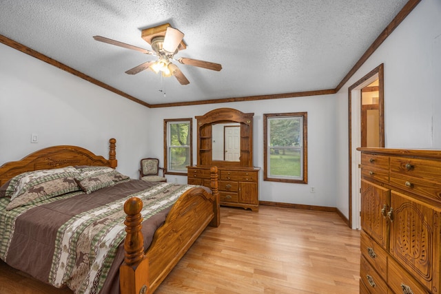 bedroom featuring multiple windows, ceiling fan, light hardwood / wood-style floors, and a textured ceiling