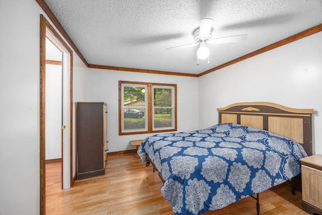 bedroom featuring ceiling fan, crown molding, a textured ceiling, and light hardwood / wood-style flooring