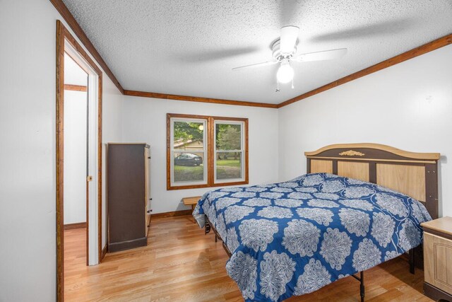 15070 Rapids Dr, Hersey, MI 49639 - bedroom featuring light wood finished floors, a textured ceiling, baseboards, crown molding, and ceiling fan