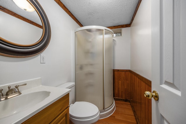 bathroom featuring vanity, wood walls, hardwood / wood-style flooring, a textured ceiling, and an enclosed shower