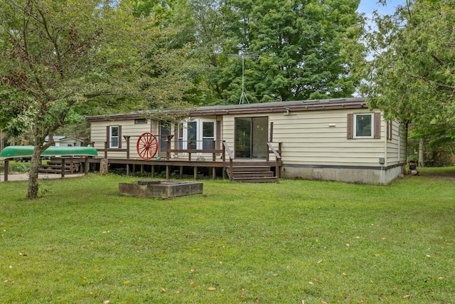 rear view of house featuring a lawn and a wooden deck