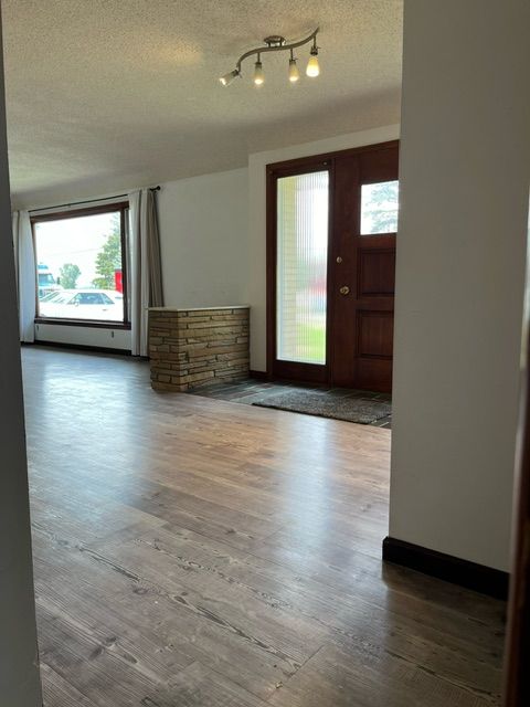 foyer entrance with wood-type flooring and a textured ceiling