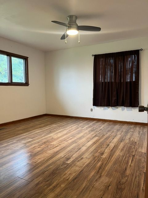 unfurnished room featuring ceiling fan and hardwood / wood-style flooring