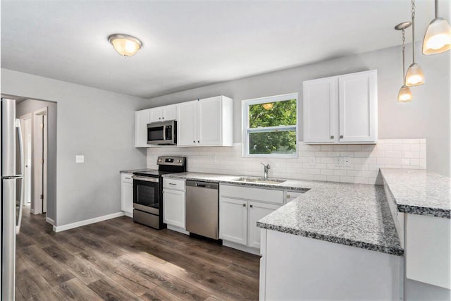 kitchen featuring tasteful backsplash, stainless steel appliances, decorative light fixtures, white cabinets, and dark hardwood / wood-style floors