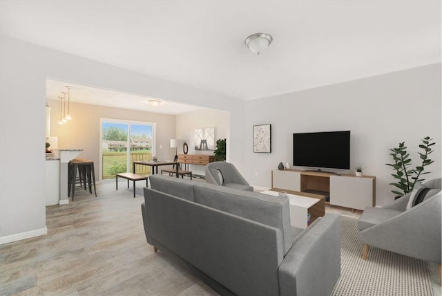 living room featuring a notable chandelier and light hardwood / wood-style floors