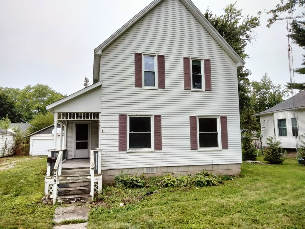 235 N Howard Ave, Croswell, MI 48422 - back of house featuring a yard, an outdoor structure, covered porch, and a garage