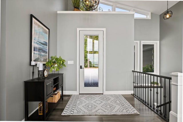 foyer with dark hardwood / wood-style flooring and vaulted ceiling