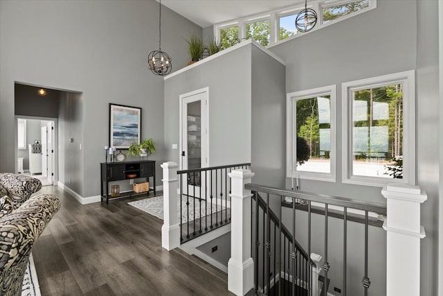 hall featuring a high ceiling, dark hardwood / wood-style flooring, and a notable chandelier