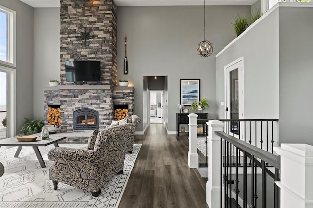 living room with a fireplace, a high ceiling, and dark hardwood / wood-style flooring