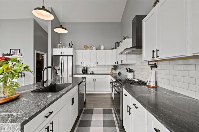 kitchen featuring white cabinetry, sink, stainless steel appliances, and wall chimney range hood