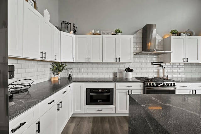 kitchen featuring white cabinetry, wall chimney range hood, and high end stainless steel range oven