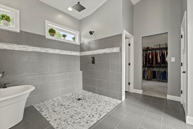 bathroom featuring tile patterned flooring, a towering ceiling, and independent shower and bath