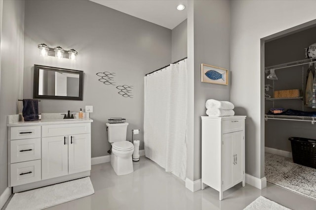 bathroom with walk in shower, vanity, concrete flooring, and toilet