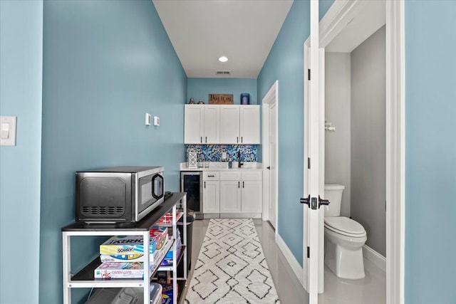 bathroom with vanity, tasteful backsplash, toilet, and beverage cooler