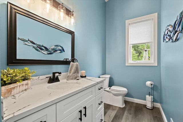 bathroom with hardwood / wood-style flooring, vanity, and toilet