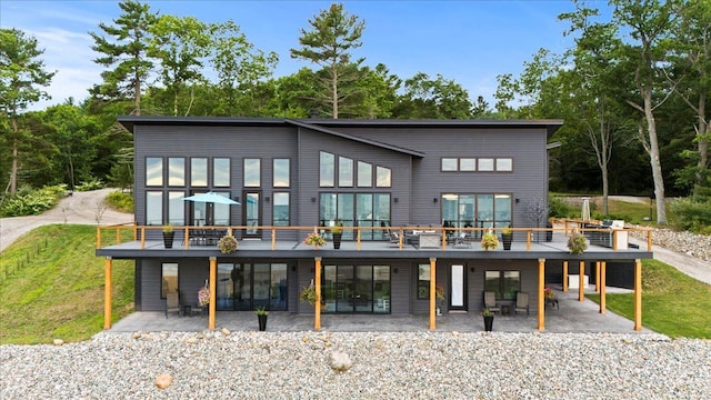 rear view of house featuring a deck and a patio area