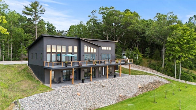 rear view of property with a lawn, a patio, and a deck