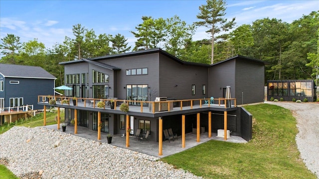 back of house with a lawn, a patio area, and a deck