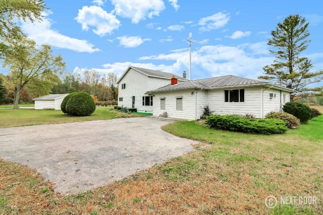 rear view of house featuring a yard