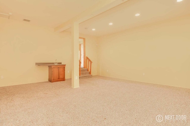 unfurnished room featuring beam ceiling and light carpet