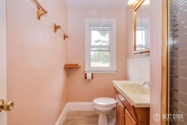 bathroom with hardwood / wood-style floors, vanity, and toilet