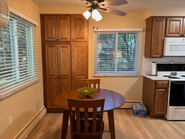 3437 3rd St Unit G, Trenton, MI 48183 - dining area featuring a baseboard heating unit, light wood-style floors, and ceiling fan