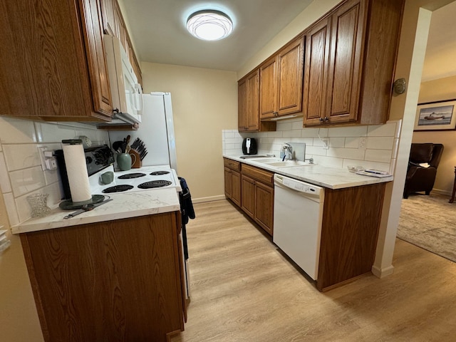 3437 3rd St Unit G, Trenton, MI 48183 - kitchen with white appliances, a sink, light wood-style flooring, and decorative backsplash