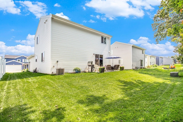 back of property with cooling unit, a patio area, and a lawn