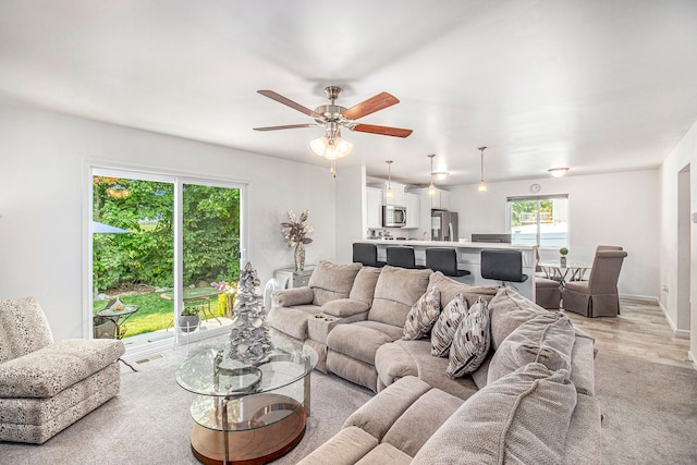 living room with ceiling fan and light wood-type flooring