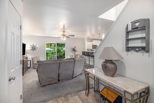 living room with ceiling fan and light wood-type flooring