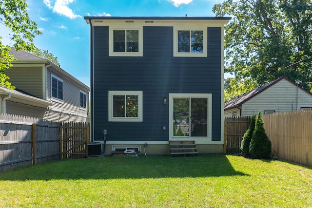 back of property with central air condition unit and a yard