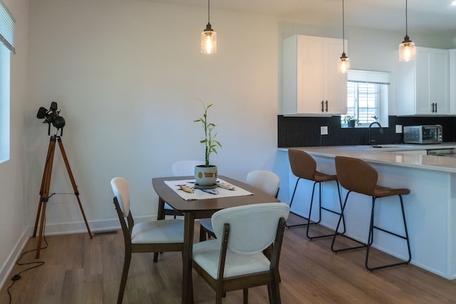 dining space featuring hardwood / wood-style floors and sink