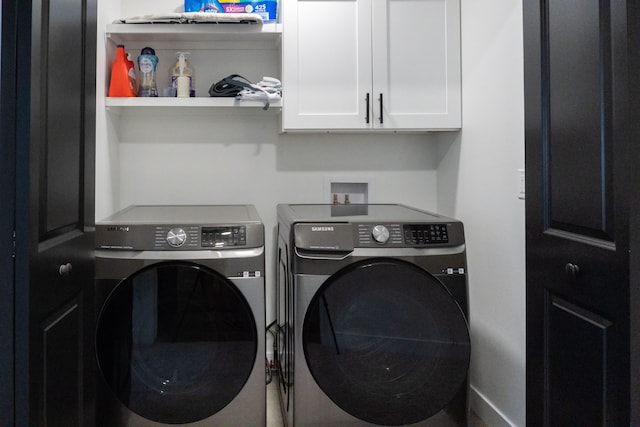 washroom featuring washer and dryer and cabinets