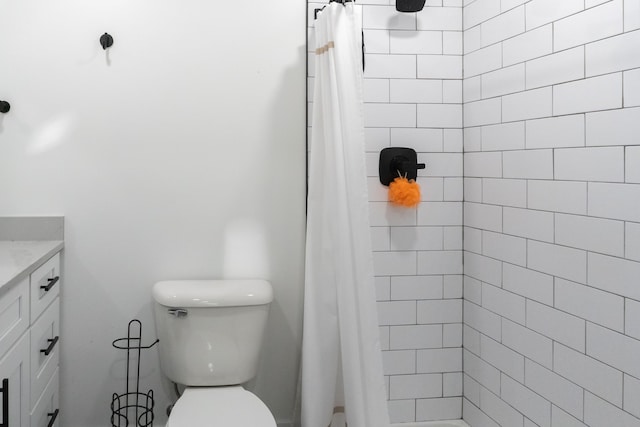 bathroom featuring a shower with shower curtain, vanity, and toilet