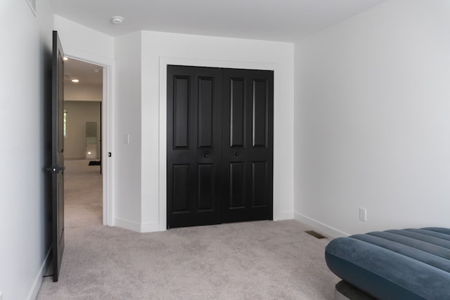 bedroom featuring light carpet and a closet